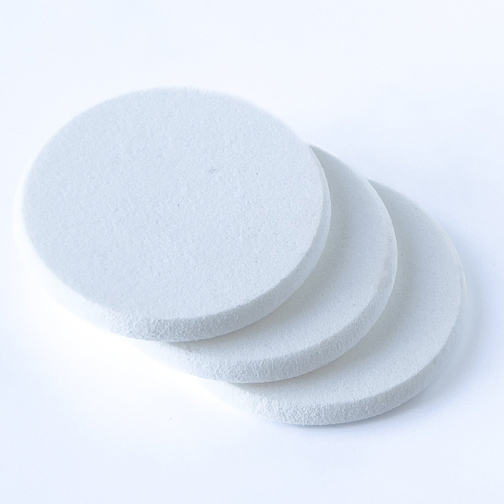 3 round, white pads are shown stacked